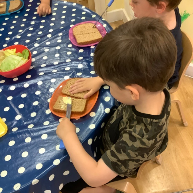 A boy buttering bread