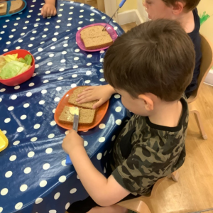 A boy buttering bread