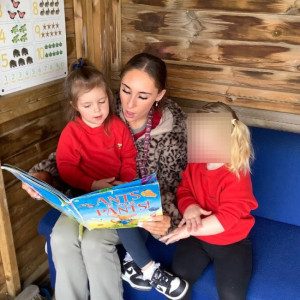 Children are reading with their teacher. 