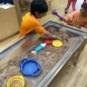 A child playing in some sand. 