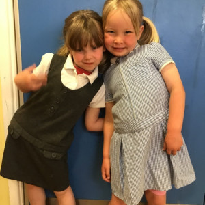 Two girls trying on school uniform. 
