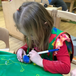Child painting on a potato 