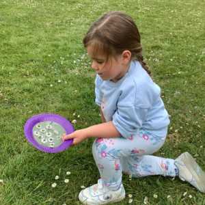 A child picking daisies. 