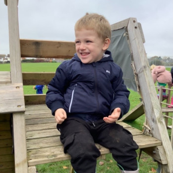Child sitting on play equipment