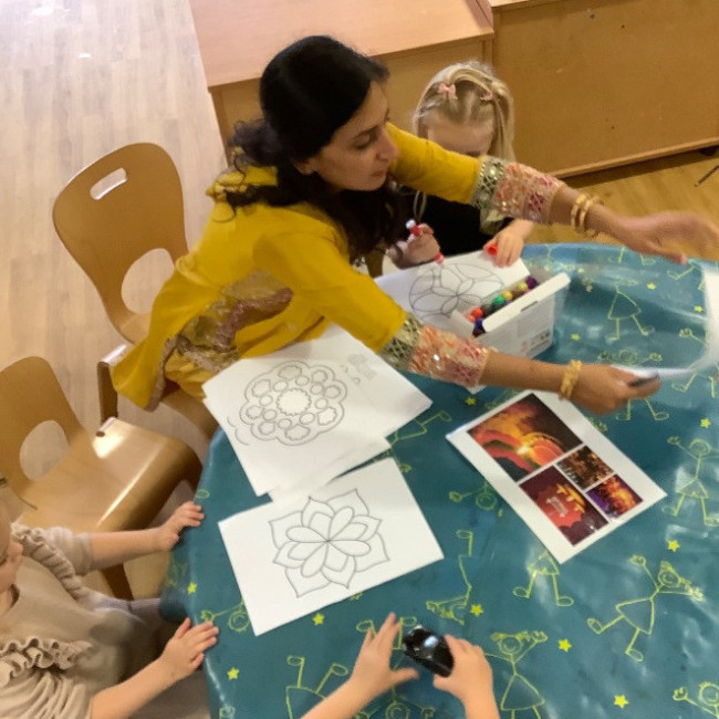 Children round a table colouring