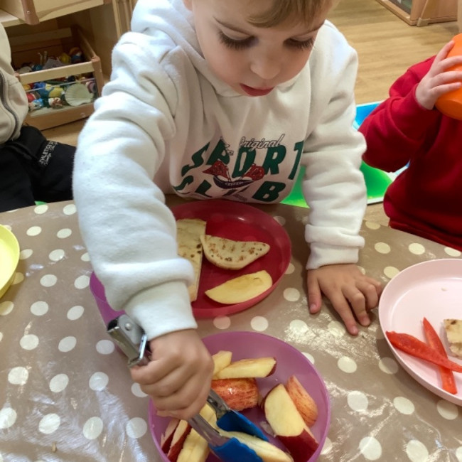 Child picking up an apple
