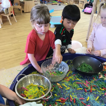 Children playing with dry pasta. 