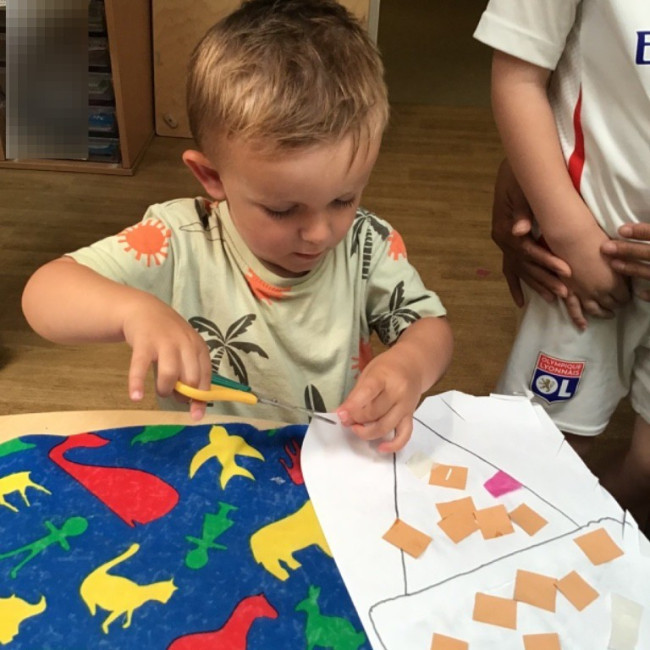 A child cutting some paper. 