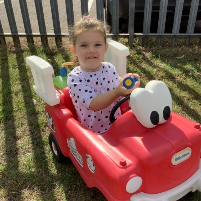 A child playing in a red car 
